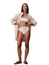 Calvin Klein bikiniunderdel med høy midje i Antique White på modell med matchende topp og åpen skjorte.