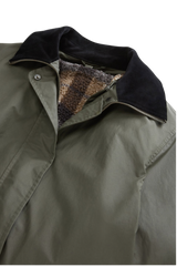 Woolrich Waxed Coat i olivengrønn med mørk krage, sett forfra.