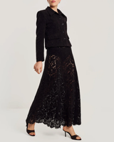 byTiMo Lace Velvet Skirt i sort med blomstermønstrede blonder og bølget kant, sett forfra på modell. 