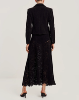 byTiMo Lace Velvet Skirt i sort med blomstermønstrede blonder og bølget kant, sett bakfra på modell. 