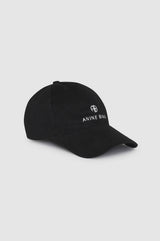 Anine Bing Jeremy Baseball Cap i sort med brodert AB-logo i hvitt, fotografert fra siden på grå bakgrunn
